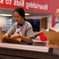 Two students loading food into boxes